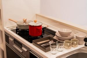 a kitchen with a stove with pots and pans at Poka Premium Kuramae Luxury 2BR Suite Brand-New in Tokyo