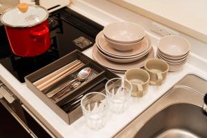 a kitchen counter with a sink with plates and dishes at Poka Premium Kuramae Luxury 2BR Suite Brand-New in Tokyo +45 photos