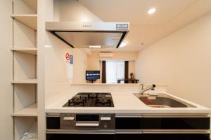 a kitchen with a stove and a sink at Poka Premium Kuramae Luxury 2BR Suite Brand-New in Tokyo