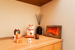 a wooden shelf with figurines of cats and a picture at Poka Premium Kuramae Luxury 2BR Suite Brand-New in Tokyo