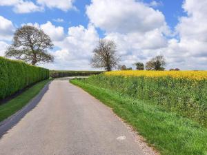 a dirt road next to a field of flowers at Plough Cottage in Anderby +2 photos