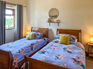 a bedroom with two beds with blue sheets at Plough Cottage in Anderby