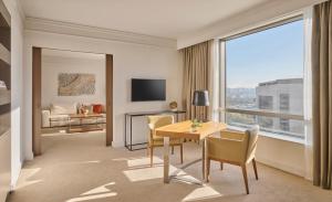 a hotel room with a table and chairs and a large window at Hyatt Regency Belgrade in Belgrade