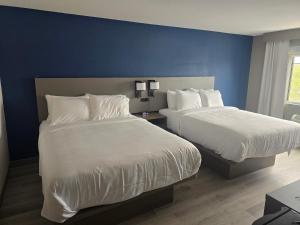 two beds in a hotel room with blue walls at Rodeway Inn in Portage
