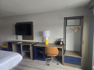a bedroom with a desk with a bed and a chair at Rodeway Inn in Portage +4 photos
