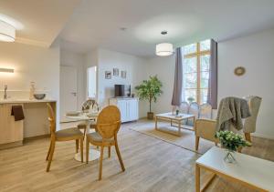 a living room with a table and chairs and a kitchen at Résidence de Bergerac in Bergerac