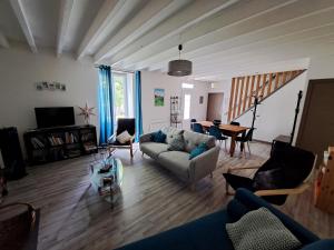a living room with a couch and a table at Le Cottage de Paul et Angéline in Boismé