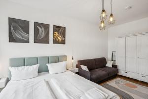 a bedroom with a large bed and a chair at Arbio I Modern Apart near Leipzig Stötteritz in Leipzig