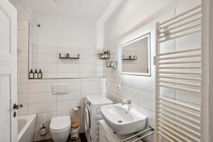 a white bathroom with a sink and a toilet at Arbio I Modern Apart near Leipzig Stötteritz in Leipzig