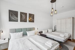 two beds in a room with white walls at Arbio I Modern Apart near Leipzig Stötteritz in Leipzig