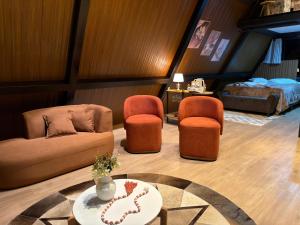 a living room with a couch and two chairs and a bed at Cabana Silêncio das Pedras in Três Coroas