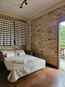 a bedroom with two beds and a brick wall at Sítio do Bosco Park in Tianguá +37 photos