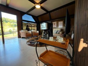 a living room with a coffee maker on a table at Cabana Silêncio das Pedras in Três Coroas
