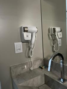 a bathroom with two phones on the wall at Areiao Park Hotel in Goiânia
