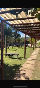 a park with a bench under a wooden pergola at Chácara Bosque da Paz in Ibiúna