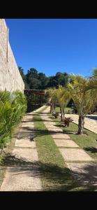 a pathway with palm trees on the side of a building at Chácara Bosque da Paz in Ibiúna
