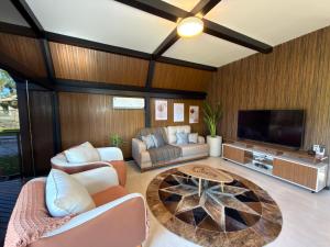 a living room with a couch and a tv at Cabana Silêncio das Pedras in Três Coroas