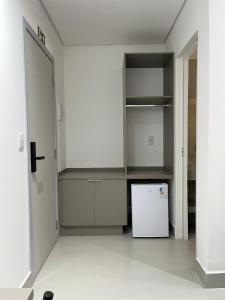 an empty kitchen with a refrigerator and shelves at Areiao Park Hotel in Goiânia +12 photos