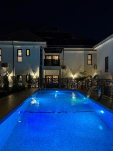 a swimming pool at night in front of a house at ASFARO Apartments in Abuja