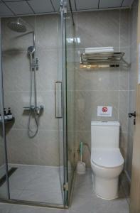 a bathroom with a toilet and a glass shower at Khiimori Hotel in Ulaanbaatar