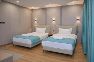 two beds in a room with blue and white at Khiimori Hotel in Ulaanbaatar