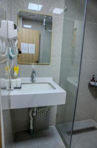 a bathroom with a white sink and a mirror at Khiimori Hotel in Ulaanbaatar +1 photo