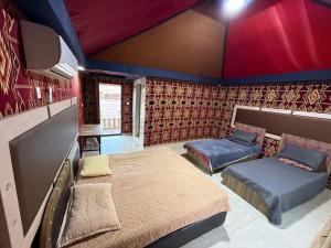 a bedroom with two beds in a room at Rayyan Bedouin life camp in Wadi Rum +167 photos