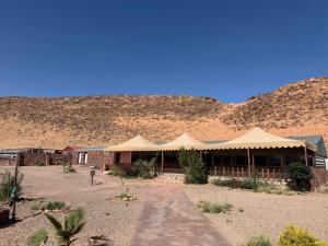 a building in the desert with a mountain in the background at Rayyan Bedouin life camp in Wadi Rum