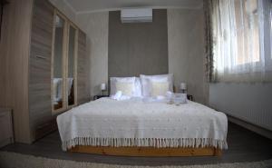 a bedroom with a large bed with white sheets and pillows at Centrum Apartman in Nagykálló