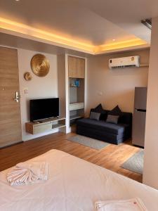 a living room with a couch and a television at Breezy Studio Aonang in Ao Nang Beach +3 photos