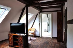 a living room with a tv on a wooden table at Ferienhaus Rosengarten Mürlenbach in Mürlenbach +23 photos