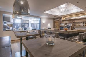 a restaurant with wooden tables and chairs and a bar at Heart Hotel Grischuna in Sankt Anton am Arlberg