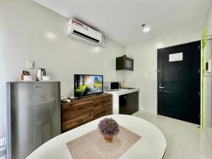 a small kitchen with a table and a refrigerator at TWD 716 Cityscape in Bacolod
