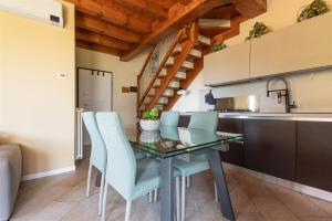a kitchen with a glass table and blue chairs at IseoLakeRental - Casa Lani in Costa Volpino