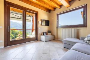 a living room with a couch and a sliding glass door at IseoLakeRental - Casa Lani in Costa Volpino