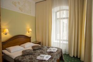a hotel room with a bed with towels on it at Hotel St. Barbara in Tallinn +37 photos