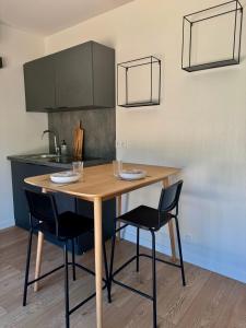 a kitchen with a wooden table and two chairs at Lodges sous les oliviers in Propriano