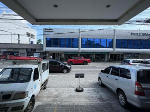 a parking lot with cars parked in front of a building at TWD 716 Cityscape in Bacolod +1 photo