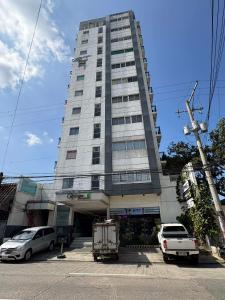 a tall building with cars parked in front of it at TWD 716 Cityscape in Bacolod