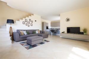 a living room with a couch and a tv at IseoLakeRental - Casa Cuneo in Costa Volpino