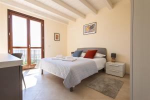 a white bedroom with a bed and a window at IseoLakeRental - Casa Cuneo in Costa Volpino +33 photos