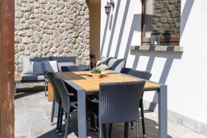 a wooden table and chairs on a patio at IseoLakeRental - Casa Cuneo in Costa Volpino