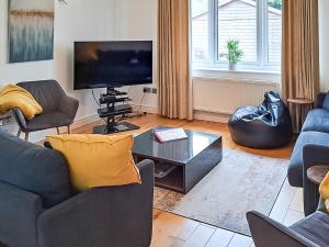 a living room with a couch and a tv at Riverside in Wimblington