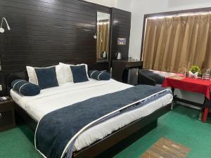 a bedroom with a large bed and a red table at Le-Leisure Hotel in Prayagraj