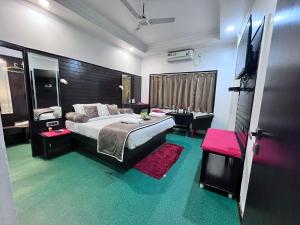 a bedroom with a large bed and a tv in it at Le-Leisure Hotel in Prayagraj