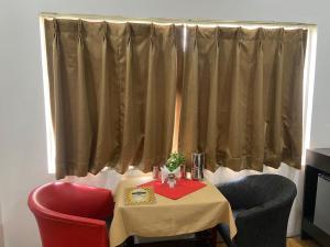 a table and a chair and a table and a window at Le-Leisure Hotel in Prayagraj +6 photos