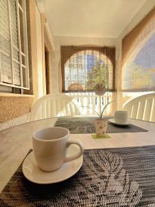 a table with a cup on a plate on a table at Bungalow Brisa de Mar in Torrevieja