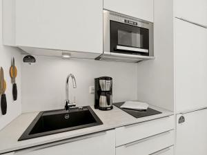 a kitchen with a sink and a microwave at Apartment Seebrise by Interhome in Lembruch