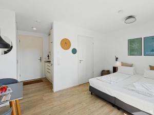 a white bedroom with a bed and a desk at Apartment Seebrise by Interhome in Lembruch
