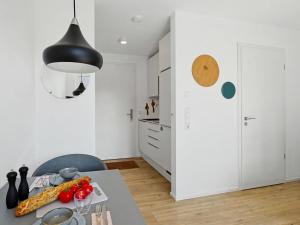 a kitchen with a table and a black light fixture at Apartment Seebrise by Interhome in Lembruch +28 photos